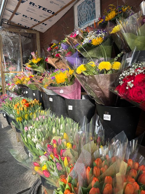 A display of freshly arranged floral bouquets at eastdulwichflowers.org.uk, featuring a variety of spring blooms including tulips in shades of pink, orange, yellow, and white. These flowers are wrappe